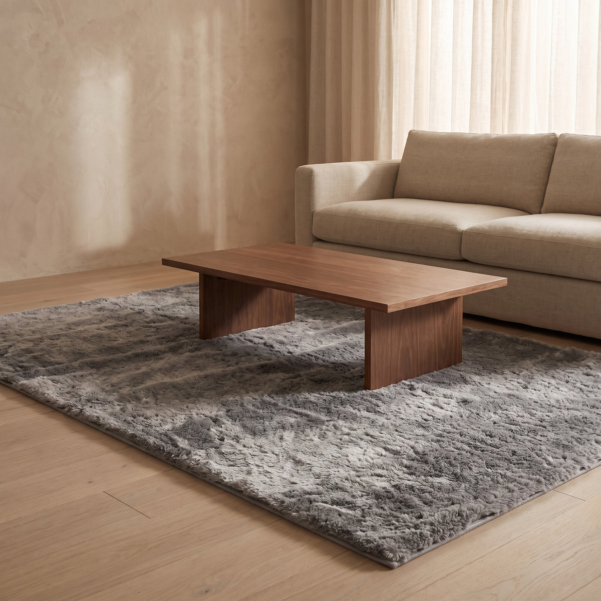 Mottled gray plush faux-fur rug under a walnut coffee table on a pale oak floor