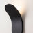 Close-up of curved metal LED wall sconce in black