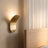 Gold wall sconce styled in a bedroom scene