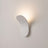 White wall sconce mounted and lit on a wall