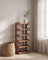 Corner shoe rack in a minimalist mudroom scene with a woven basket and olive branch