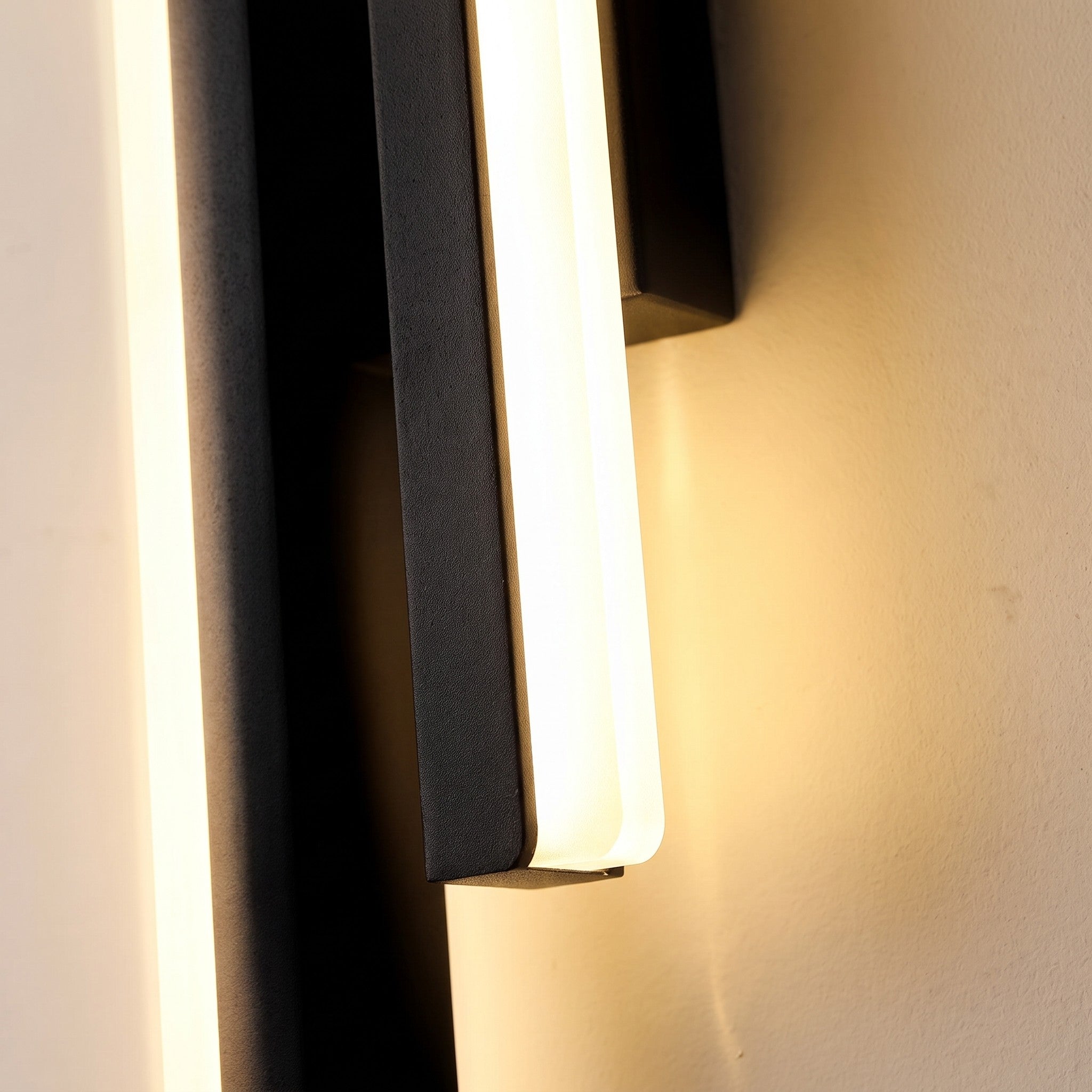 Close detail of the glowing acrylic face on the slim wall sconce