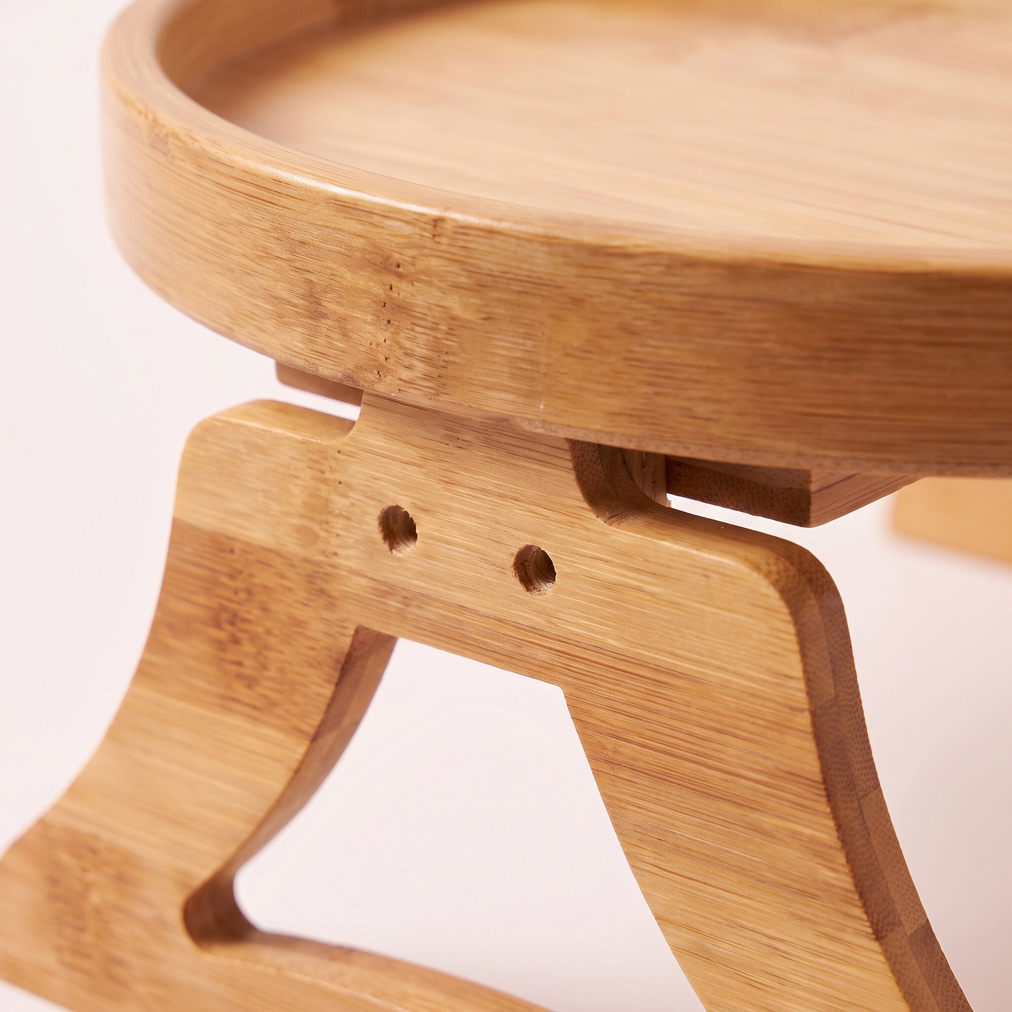 Close-up detail of the wood leg joint and grain on the sofa arm tray