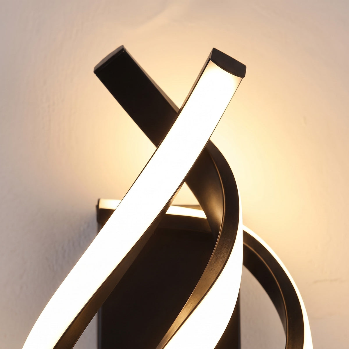 Close detail of the lit ribbon crossing the spiral sconce frame