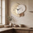 Three Pebble Silent Wall Clock hanging above a kitchen counter with ceramic pieces and an olive branch.