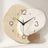 Three Pebble Silent Wall Clock — a single one-piece clock face printed with a three-tone pattern in sand texture, white marble and caramel, on an off-white studio backdrop.