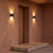 A pair of up-down wall lights either side of a porch doorway at dusk