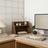 Modern office desk with computer setup, decor items, and a lamp.