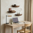 Home office with wooden desk, laptop, and chair near a window with curtains.